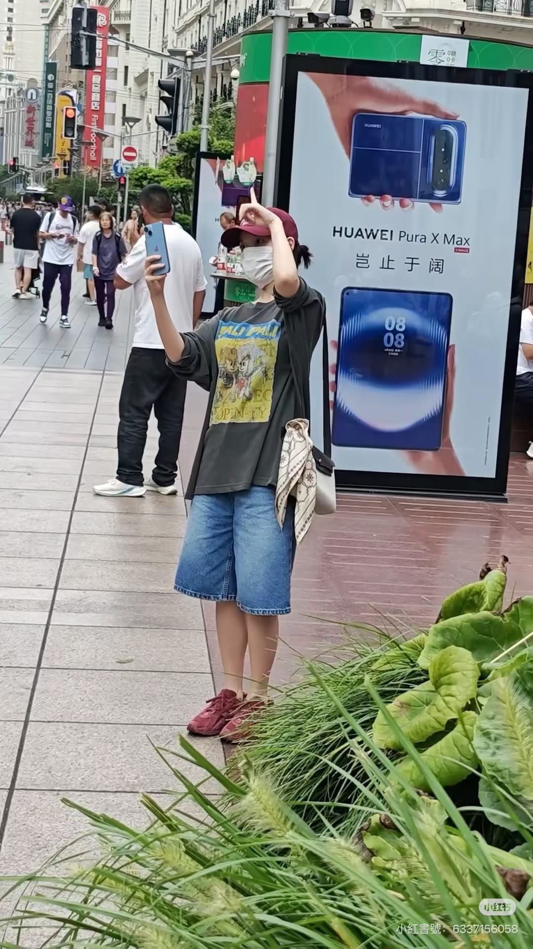 IU 的街頭穿搭：寬鬆 T 恤、丹寧短褲，配上石板灰 Mini Herbag。